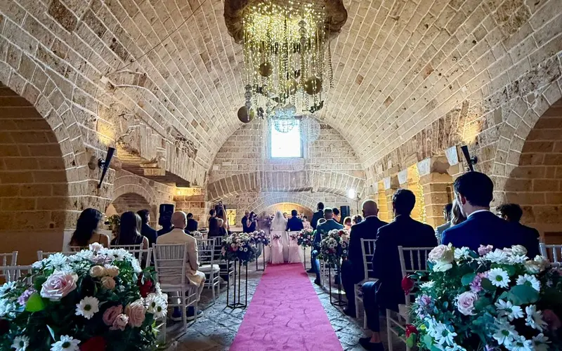 Il rito civile in sala: gli sposi in fondo alla navata, tra i fiori e il tappeto